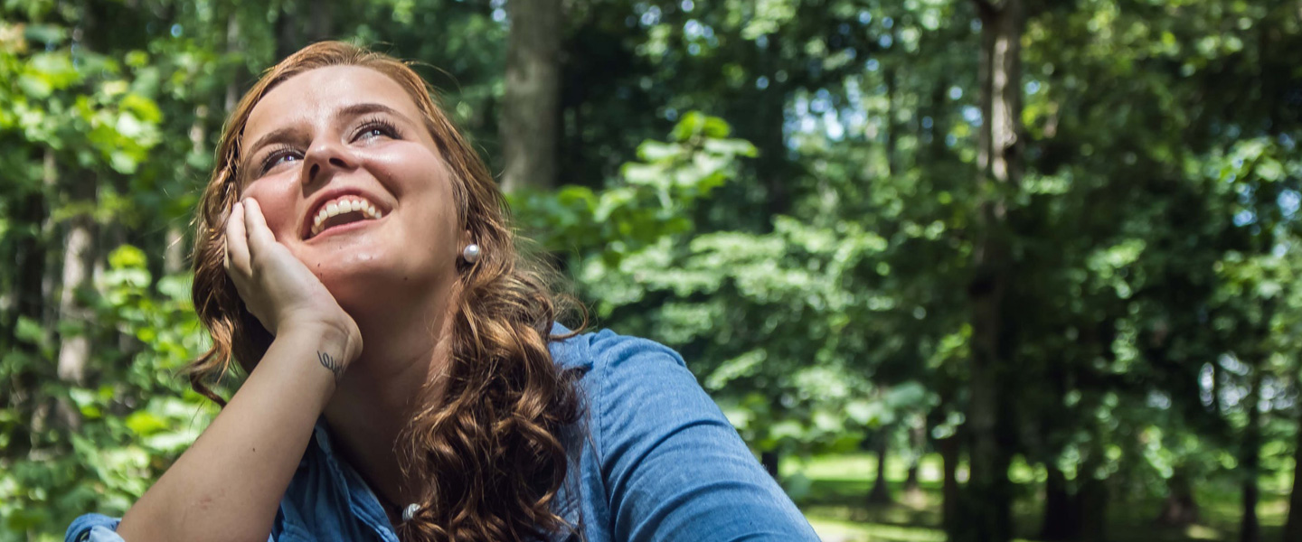 A smiling woman looking at the sky